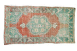 Distressed vintage Oushak rug with a scalloped medallion in terracotta and pale turquoise green.