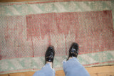 A detailed view of the distressed, low-pile texture on a vintage Anatolian runner.