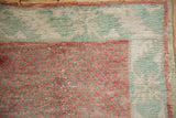 Close-up of the worn texture on the raspberry lattice field and pale mint green serrated leaf border.