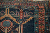 Antique Malayer rug: navy blue field, serrated leaves, madder root red and dusty teal borders.