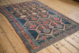 Intricate germinating plant design within panels, navy, madder red, and teal tones on Antique Malayer rug.