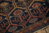 Malayer rug detail: navy, madder red germinating plant design, serrated leaves, dusty teal tones, and original selvage.