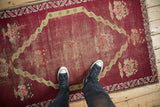 A scale view of the time-worn texture on a raspberry red antique Anatolian rug.
