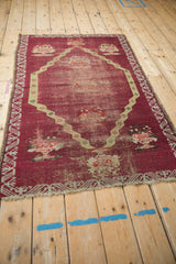 Antique Anatolian rug from an angle, displaying its full medallion design and storied patina.