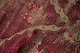 Worn hand-knotted pile revealing the foundation on a burgundy and sand antique Anatolian rug.