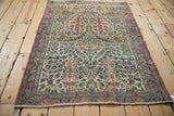 Vintage Kerman rug corner, pale cochineal red selvage, blue and cream floral border.