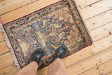 Antique Kerman rug border with cochineal red detail and blue field of blossoms and vines.