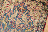 Fine antique Kerman rug detail: two ivory birds on a pictorial tree-of-life motif with blue and red blossoms.