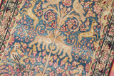 Pictorial antique Kerman rug detail: antique ivory lion, gold vines, cochineal blossoms on denim blue.