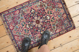 Antique Kerman hand-knotted rug detail: red, navy floral blossoms and arabesques on sand ground, showing even wear.