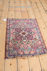 Antique Kerman rug corner: navy blue, cochineal red floral patterns, sand spandrel, and selvage.