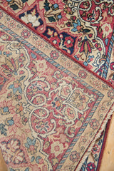Antique Kerman rug's folded corner reveals hand-knotted foundation and sand floral border.
