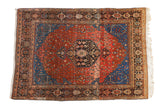 Vintage Josan Sarouk rug with a floral medallion on a madder red field and sapphire blue spandrels.