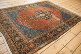 Low angle view across the vintage Sarouk rug pile showing the detailed corner and dark border.