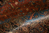 A folded sapphire blue corner spandrel showing the dense wool pile of a vintage Persian Sarouk.