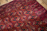 Detail of the intricate snowflake border and dense, low pile at a corner of the antique Turkmen rug.