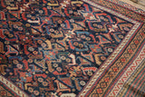 Angled view of an antique Afshar's serrated leaf pattern in vivid blues, reds, and saffron.