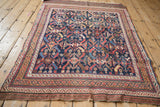 Angled perspective of an antique Afshar rug with an allover serrated leaf design in rich colors.