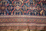 Original plain weave end showing authentic wear next to the cobalt blue and red geometric border.
