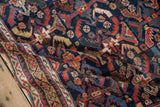 Intricate border and cobalt field of a hand-knotted antique Afshar rug, showing its rich texture.