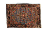 Vintage Farahan Sarouk rug with a sky blue shield medallion, dusty blush field, and a dark navy border.