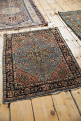 Vintage Farahan Sarouk rug with a blue shield medallion, shown in a styled setting with other rugs.