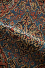A soft drape reveals the intricate, hand-knotted medallion of a vintage Persian Sarouk rug.