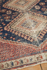 Vintage Afshar rug's hand-knotted texture with wear exposing foundation, madder root red, and navy patterns.