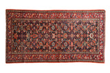 Vintage Malayer rug with a covered allover design in saturated gem tones of cherry red, navy blue, and gold.