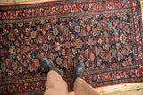 The deep, saturated gem-tones of a vintage Malayer rug with a dense allover floral pattern.