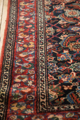 A close view of a Malayer rug's serpent design border and colorful floral cross-section.