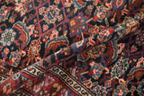 Richly colored, low pile of a vintage Malayer rug folded to show the intricate serpent border.