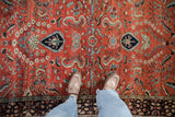 Expressive leaves and palmettes in blue and green on a vintage Sarouk's brick red field.