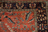 Detail of a vintage Sarouk's corner showing the navy border and polychromatic leaves on the red field.