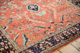 Corner detail of a vintage Sarouk rug showing the navy border and polychromatic floral field.