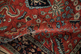 A gentle fold reveals the dense, hand-knotted pile of a vintage Persian Sarouk rug.