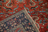 A vintage Sarouk rug's corner folded to display the hand-knotted foundation and original side cord.