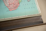 Vintage Nystrom map's lower edge showing longitude lines, wooden dowel, and paper distress.