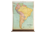 Vintage A.J. Nystrom pull-down map of South America with colorful countries, aged paper, mounted on a dowel.