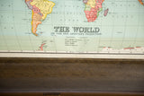 Lower edge of the vintage Nystrom world map, showing textured brown dowel and stitching.