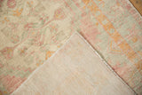 The hand-knotted construction and distressed texture of a vintage Oushak rug's pile and foundation.