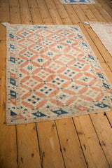 Distressed terracotta and dusty blue diamond guls with original selvage detail on vintage Turkish rug.