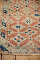Distressed Dosemealti rug corner detail, terracotta and blue geometric guls, even wear.