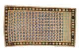 Vintage Distressed Oushak rug, dusty gold field, blue floral pattern, brown starburst border. 2'4