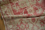 The soft, distressed texture and low pile of a folded vintage Turkish Oushak runner.