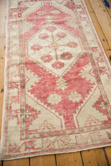 Distressed vintage Oushak rug detail, showcasing faded raspberry floral and vine motifs.