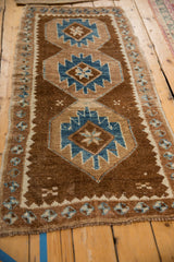 Distressed Kars rug detail: chocolate brown, sapphire blue geometric medallions and serrated motifs.