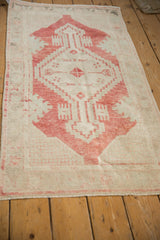 Vintage distressed Turkish Oushak rug seen from an angle, highlighting the low pile and faded texture.