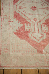 Even wear to the foundation on a vintage Oushak rug with faded red geometric corner designs.
