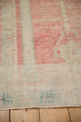 Close-up of the mostly even wear and geometric turquoise border on a pale blush Oushak rug.